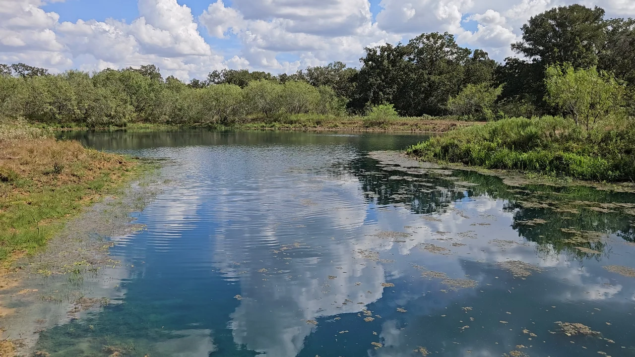 Stock tank on the ranch with clouds reflected in the water